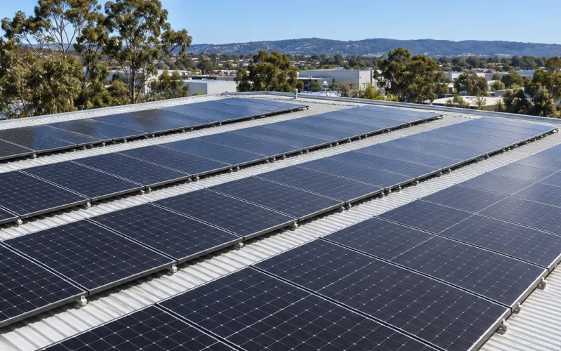 Rows of solar panels across a wide commercial metal roof