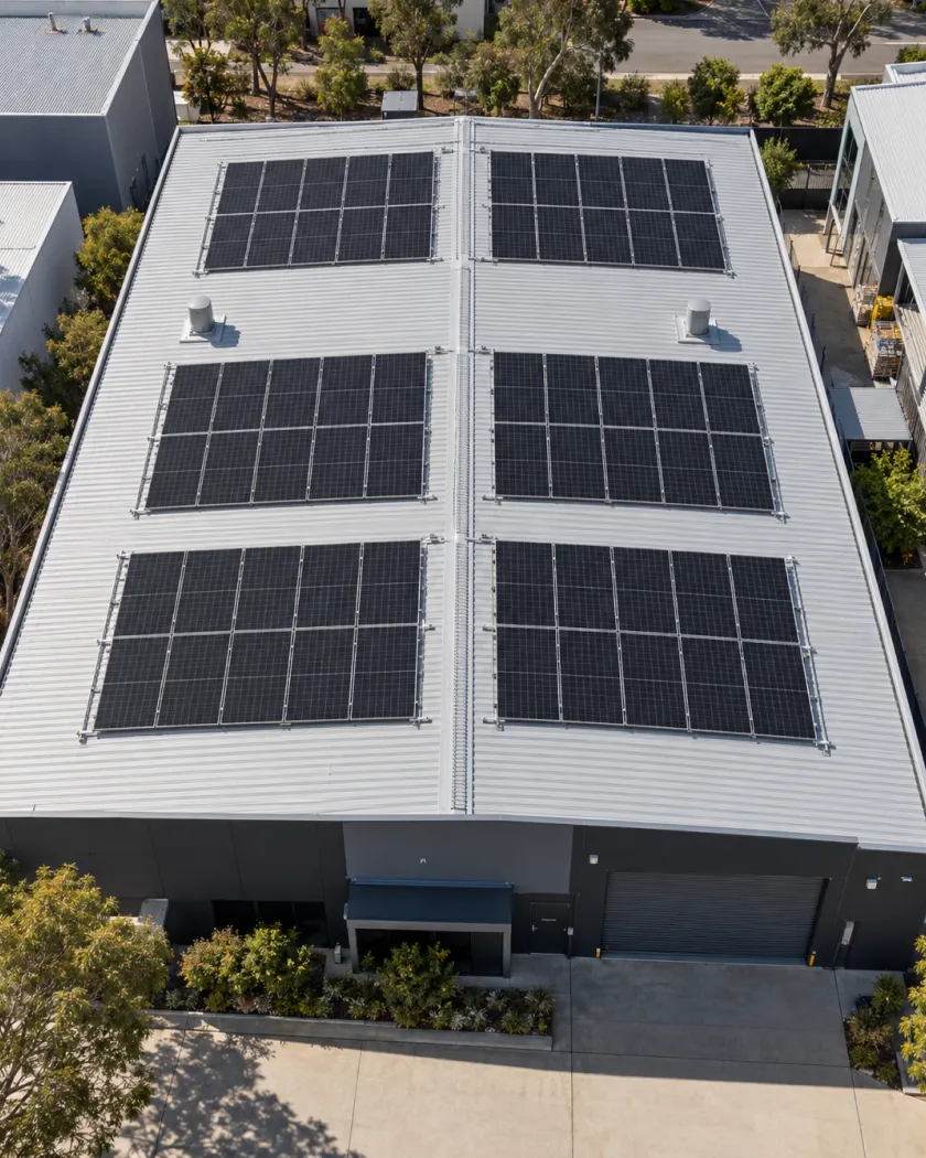 Aerial view of six blocks of solar panels on a warehouse roof