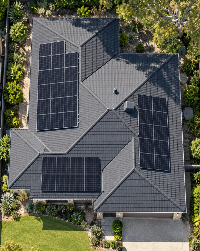 Aerial view of a home roof with three groups of solar panels